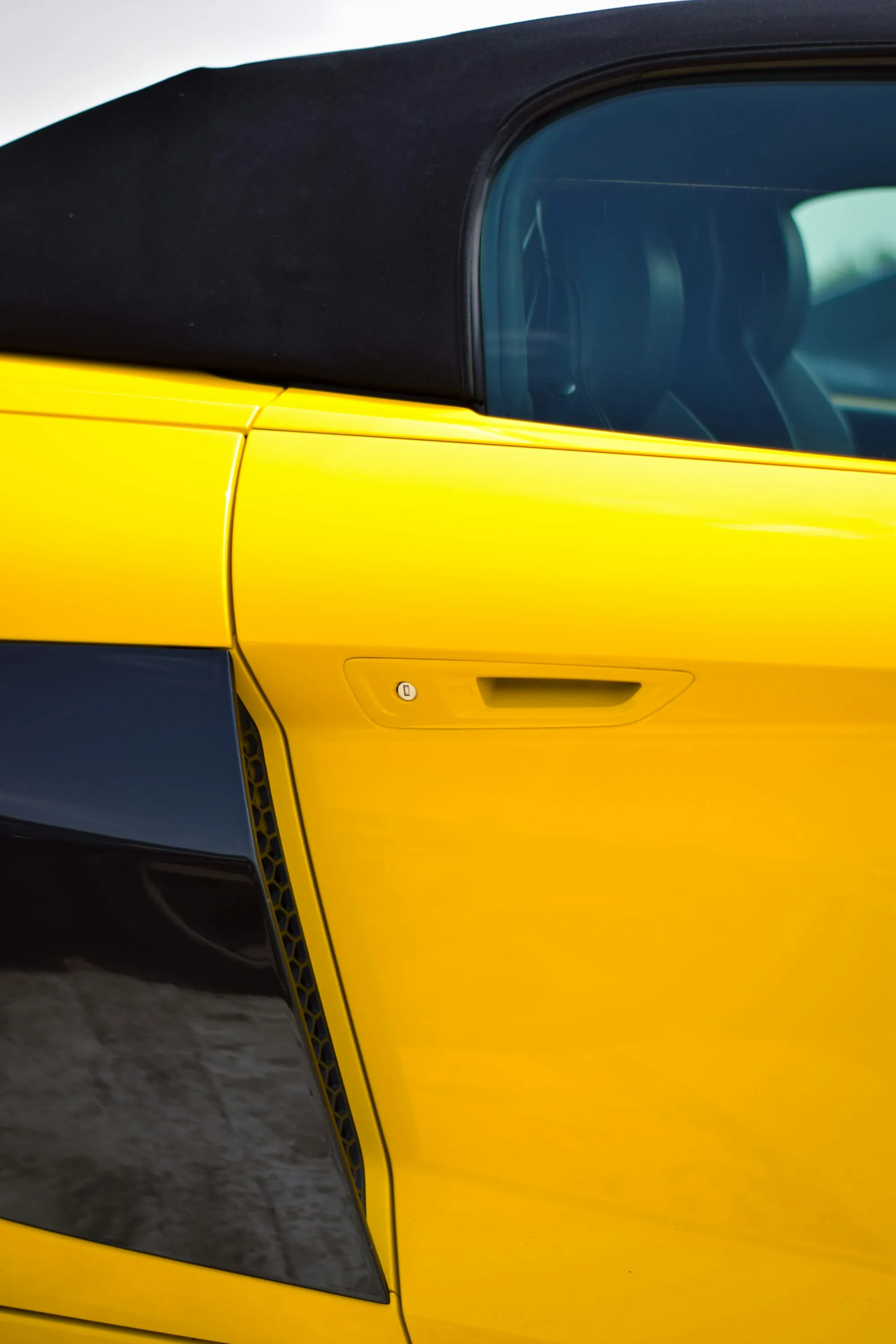 Close-up of the door and side panel of a yellow convertible